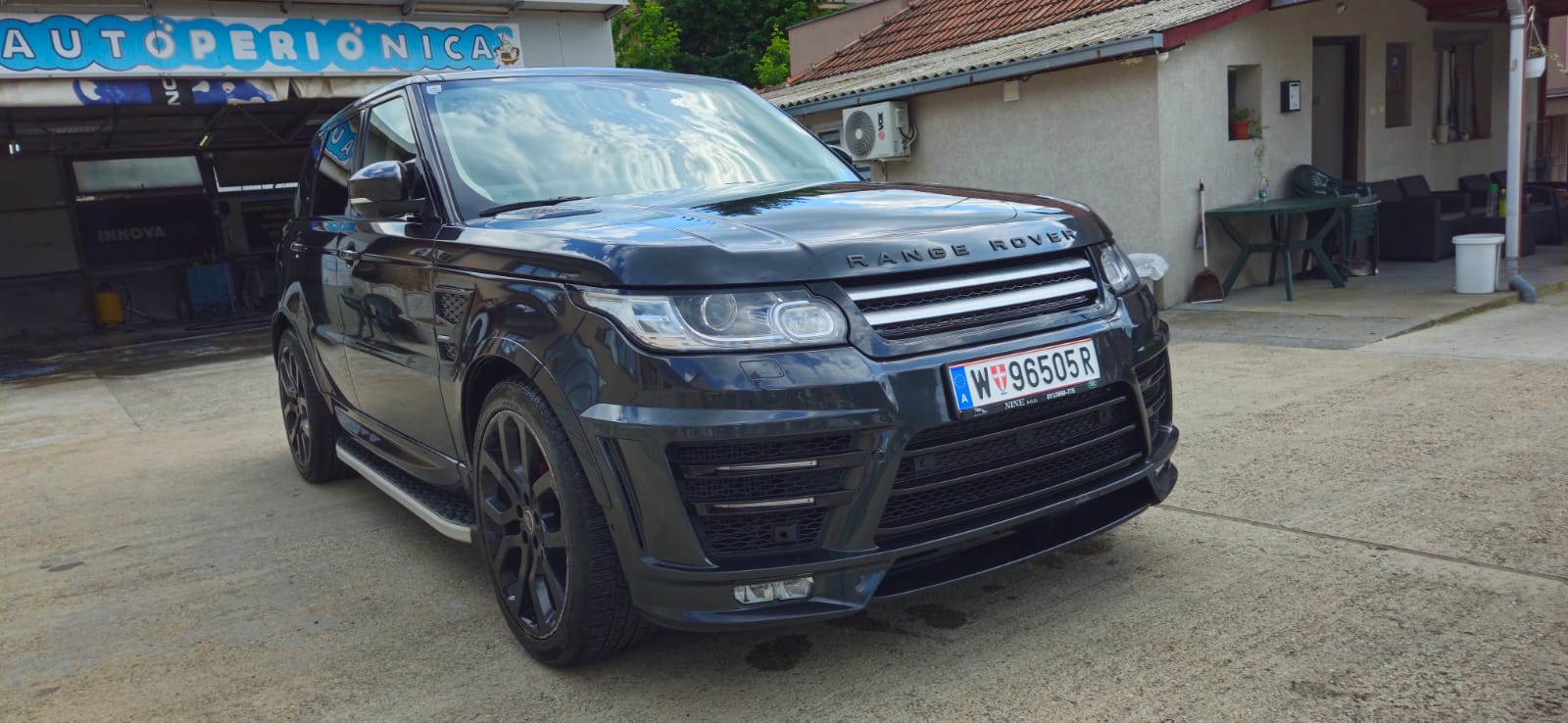 Sjajan, mokar tamno plavi automobil sa kapljicama vode